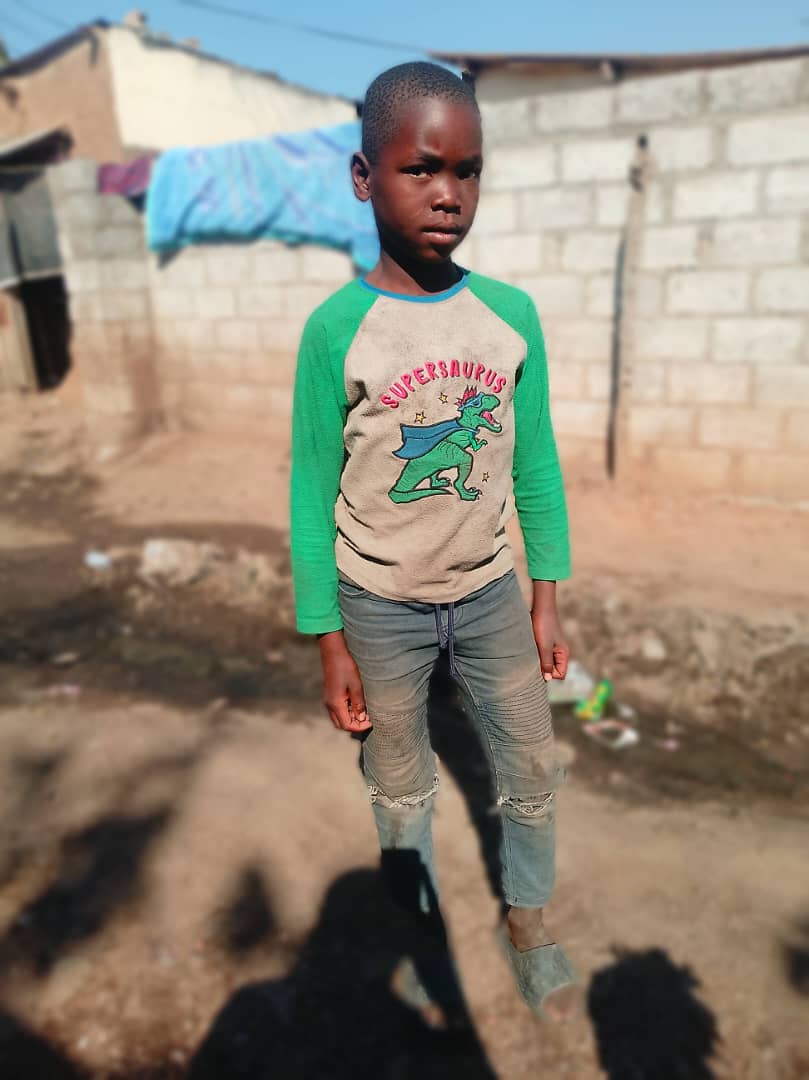 A young boy standing in a Zambian neighborhood