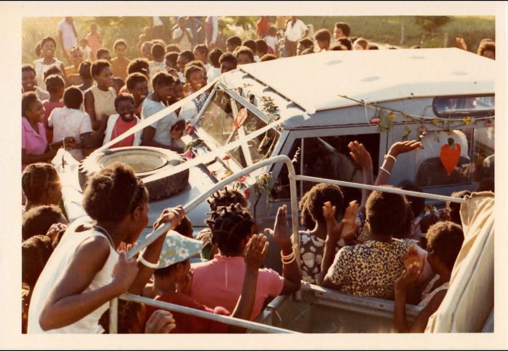 Sue Pujdak's parents celebrated by a crowd on a decorated vehicle in Zambia, 1973